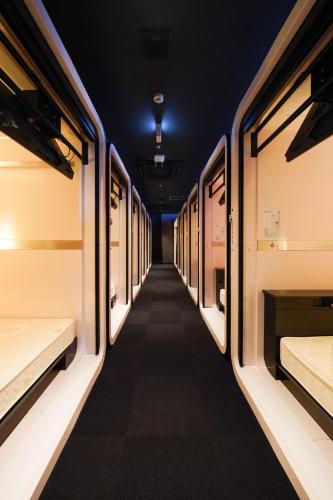 a corridor of a train with beds in it at ファーストキャビン松江 in Matsue