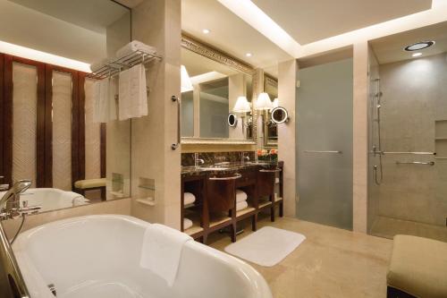a bathroom with a tub and a sink and a shower at Shangri-La Qingdao - May Fourth Square in Qingdao