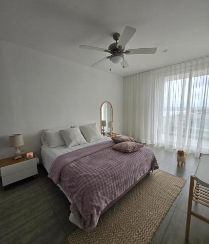 a bedroom with a bed and a ceiling fan at Luxury Oceanfront Apartment Spiaggia 2BR 3BA Playa azul Cartagena in Cartagena de Indias