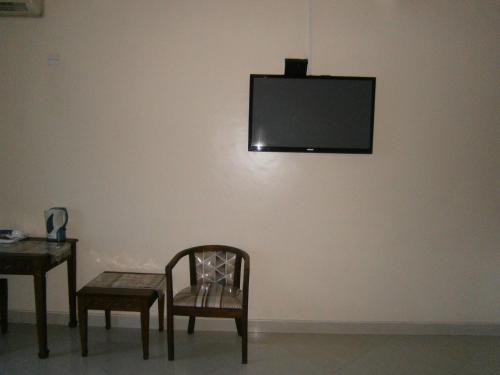 a chair and a table and a television on a wall at Tudor Water Sports Hotel in Mombasa