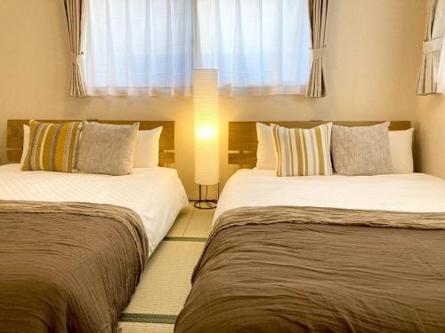 two beds sitting next to each other in a bedroom at Neo Universal 05 in Wada