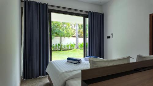 a bedroom with a bed and a large window at Pulau Indah Lombok in Kuta Lombok