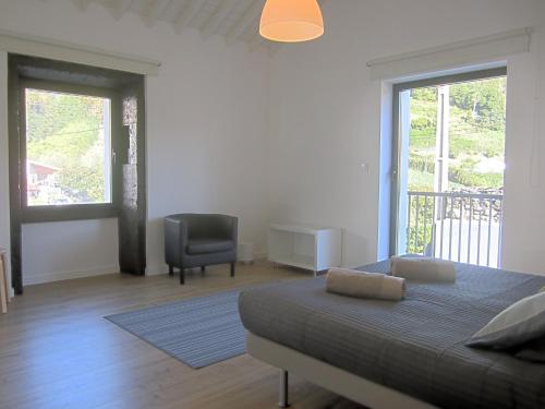 a bedroom with a bed and a chair and a window at Furnas Valley in Furnas