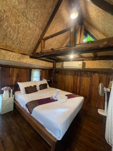a bedroom with a large bed in a room at Baancherda in Ban Nong Hu