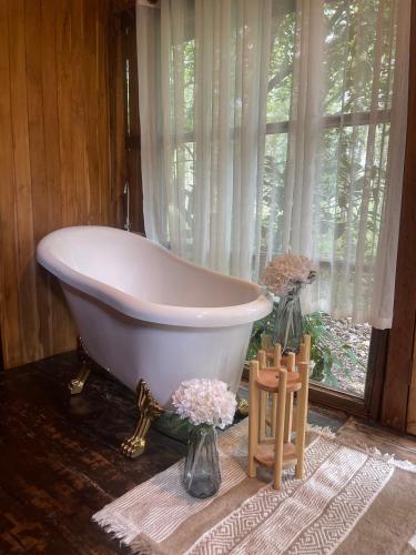 a white bath tub sitting in a room with a window at Baancherda in Ban Nong Hu