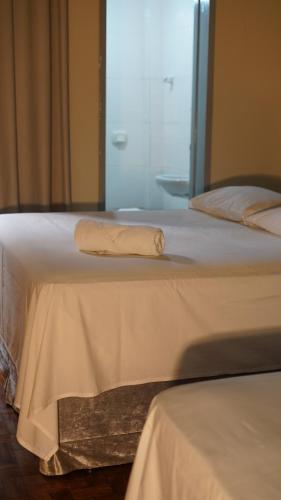 a white bed with a towel on top of it at Hotel Joia in Cascavel