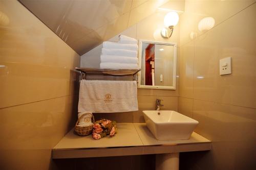 a bathroom with a sink and a mirror and towels at Avraham Hotels in Machu Picchu