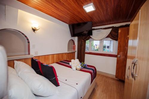 a small room with a bed and a tv on a boat at Avraham Hotels in Machu Picchu