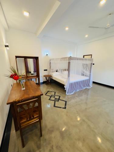 a room with a bed and a table and a table sidx sidx at Villa Paddy Heaven in Unawatuna