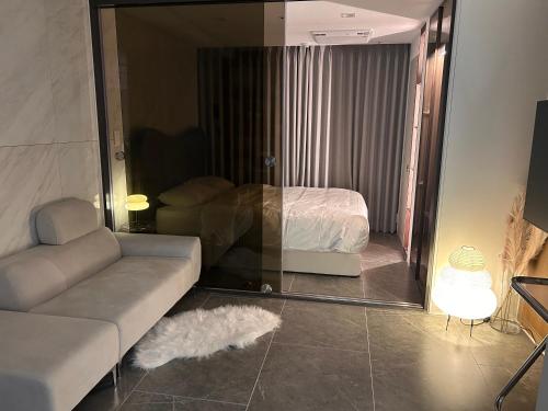 a living room with a couch and a bed in a mirror at 케이 코지 하우스 - 스튜디오 in Seoul