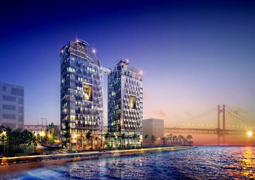 two tall buildings next to a river with a bridge at 오션스테이 호텔 in Busan