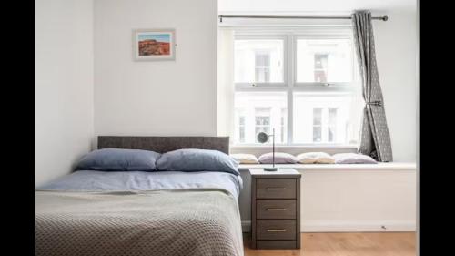 a bedroom with a bed and a window at ApartmentA in Derry Londonderry