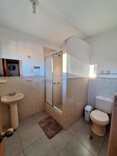 a bathroom with a shower and a toilet and a sink at Casa Wayra Cajamarca in Cajamarca
