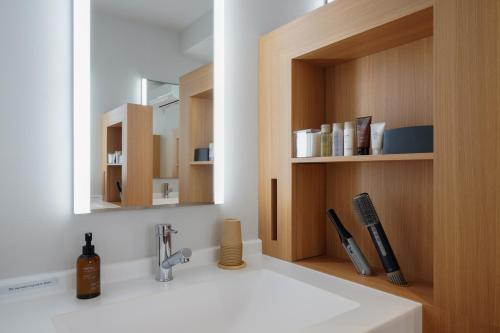 a bathroom with a sink and a mirror at ファーストキャビン松江 in Matsue
