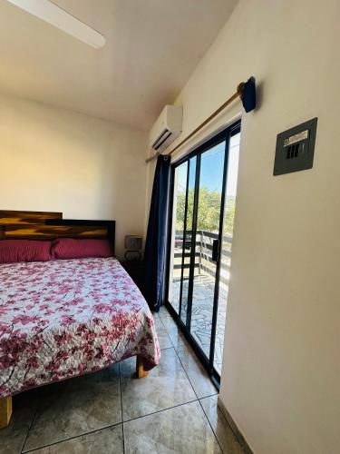 a bedroom with a bed and a large window at Adonai in Rincon de Guayabitos