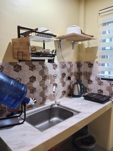 a kitchen with a sink and a counter top at Bluewaves Apartment, scooter in Dauis