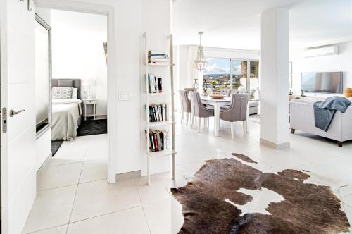 a white living room with a table and a dining room at CP - Modern Beachside Apartment in Estepona in Estepona