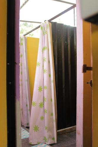 a window with a pink curtain with green crosses at Mantra Homestay in Bacalar