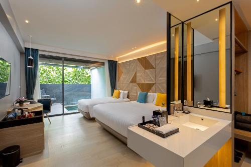 a bedroom with a bed and a sink and a mirror at The Nature Phuket in Patong Beach