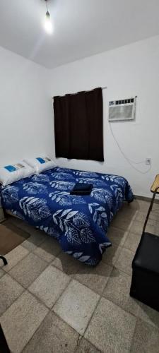 a bedroom with a bed with a blue blanket at Alquileres BH in La Rioja