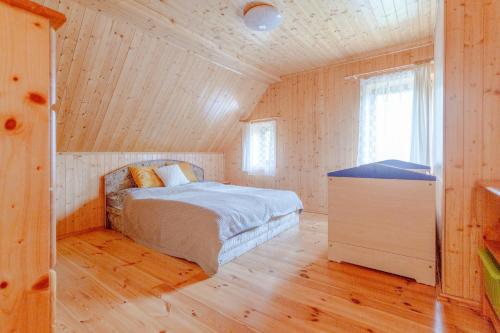 a bedroom with a bed in a wooden cabin at Chalupa u Bruna in Ruprechtice