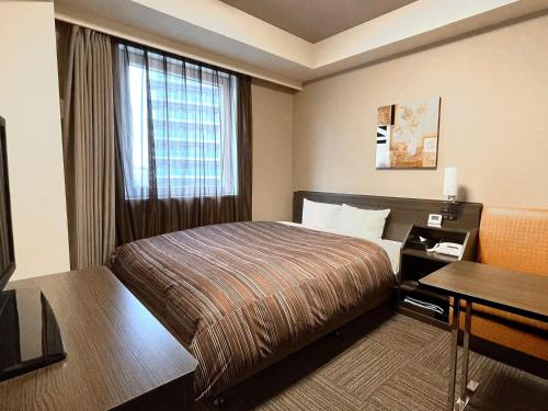 a hotel room with a bed and a window at Hotel Route-inn Ebina Ekimae in Ebina