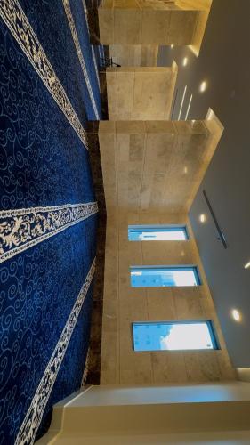 a staircase with blue and white walls and a window at فندق الروضة المتحدة Hotel AL Rawdah United in Al Khansāk