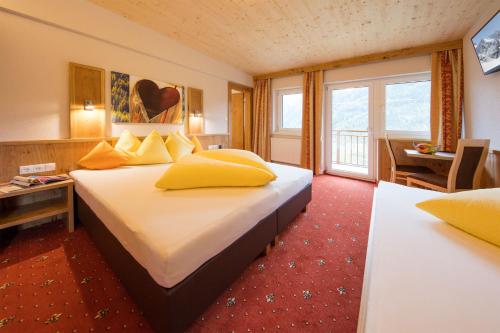 Pokój hotelowy z dużym łóżkiem z żółtymi poduszkami w obiekcie Haus Stefanie w Solden