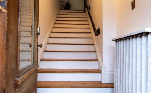 a set of stairs in a home with a wooden door at Swanky Shaw 2BR with Office ABODEbucks in Tower Grove