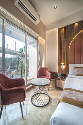 a hotel room with a bed and a table and chairs at Hotel Royal Inn in Thane