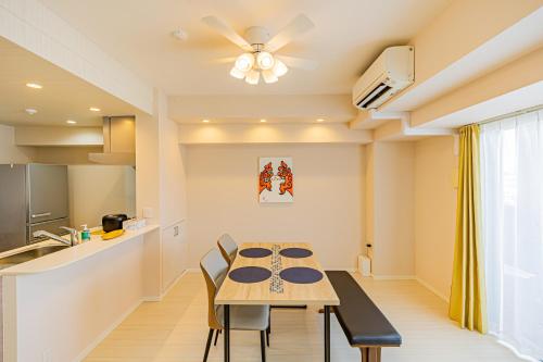 a kitchen and dining room with a table and chairs at Yenn's Plaza Rycom -エンズプラザライカム- in Okinawa City