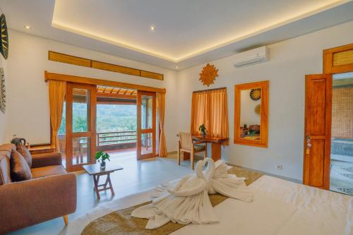 a bedroom with a large bed and a living room at Villa Karma Loka in Sidemen