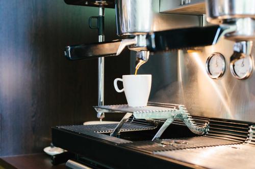 a coffee maker is making a cup of coffee at Chester Hotel Heidelberg in Heidelberg