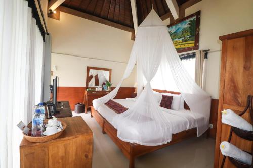 a bedroom with a bed with mosquito net at Villa JJ and Spa Ubud in Ubud