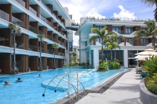a swimming pool in a hotel with people in it at The Sunshine Beach Resort Studio in Layan Beach