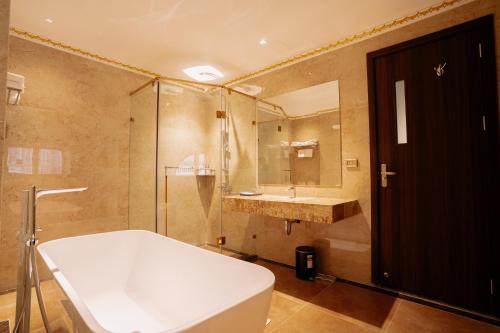 a bathroom with a tub and a sink and a shower at Bao An Hotel Hung Yen in HÆ°ng YÃªn