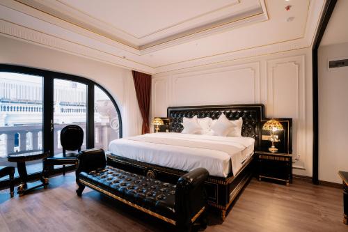 a bedroom with a bed and a bench in it at Bao An Hotel Hung Yen in HÆ°ng YÃªn