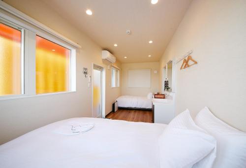 a bedroom with a white bed and a window at THE BOXY AWAJI in Awaji