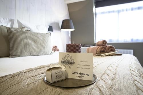 a hotel room with a sign on a bed at B&B BE IN BRUSSELS in Brussels