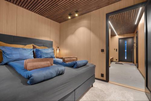 a bedroom with a large bed with blue pillows at Signature Townhouse for Luxury Living Arctic Seasons in Tromsø