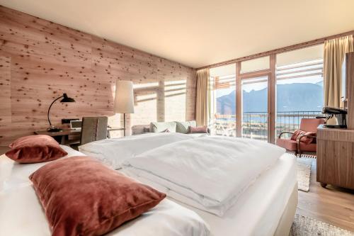 a bedroom with a large bed and a large window at NIDUM - Casual Luxury Hotel in Seefeld in Tirol
