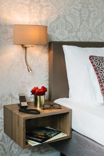 a bed with a night stand next to a bed with a bed gmaxwell gmaxwell gmaxwell at Chester Hotel Heidelberg in Heidelberg