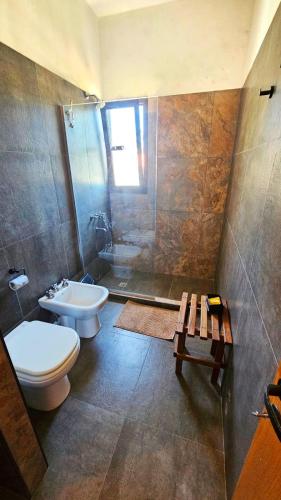 a bathroom with a toilet and a sink and a shower at Terrazas al Golf in Alta Gracia