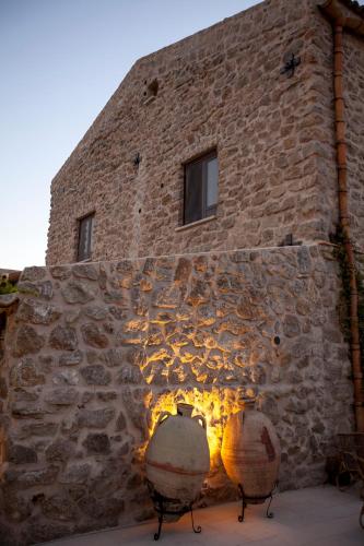a stone building with two large pots in front of it at Masseria Agnello in Realmonte