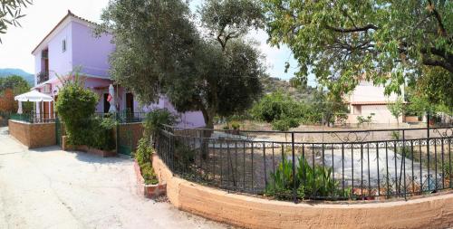 a purple house with a fence in front of it at Vassilis Studios in Anaxos