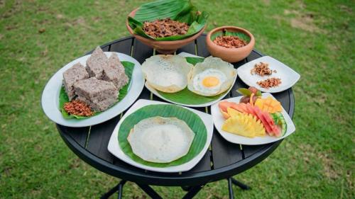 a table with plates of food on top of it at Ayana Gardens Ella in Ella