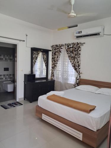 a bedroom with a large bed and a bathroom at Love Villa in Kottiyam