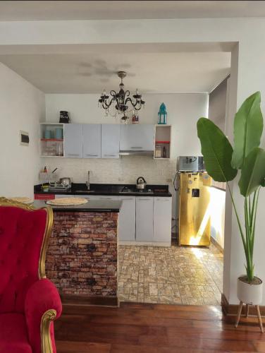 a kitchen with white cabinets and a red couch at Depa Excelente Vintage in La Molina