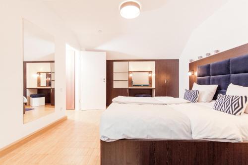 a bedroom with a large bed with a blue headboard at Appartement mit Dachterrasse und Schloßblick in Heidelberg