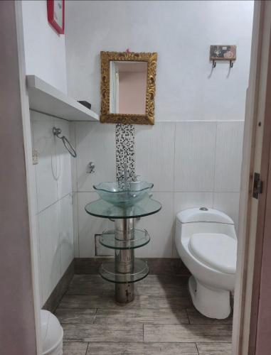 a bathroom with a sink and a toilet and a mirror at Depa Excelente Vintage in La Molina